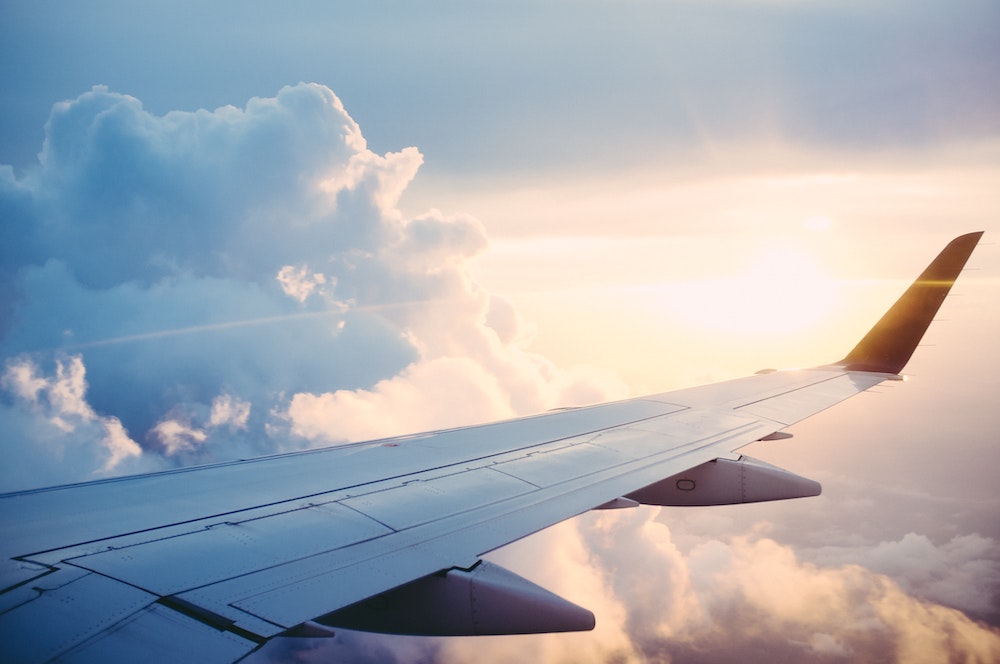 Photo from a plane with view to clouds and the sun.